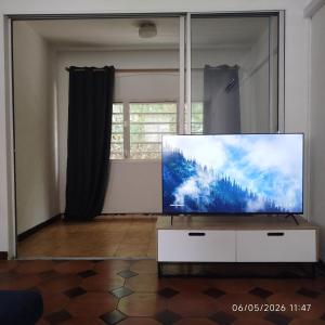 a living room with a large flat screen tv at Tikanel in Schœlcher