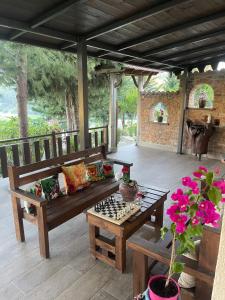 a wooden bench sitting on a deck with a chessboard at Forest House in Berat