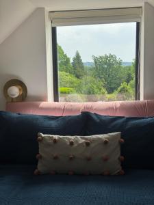 a pillow sitting on a couch in front of a window at Little Rozel in East Grinstead