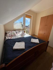 a bedroom with a bed with two towels on it at SAViTA in Karwia +24 photos