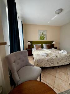 a bedroom with a bed and a chair at Pensjonat Krystyna in Rewa