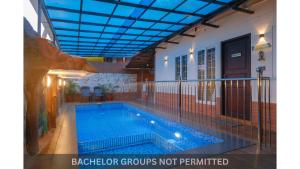 a swimming pool in a house with a blue ceiling at Jonirene Seasands Homestay in Alleppey