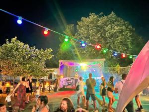 a group of people standing around a stage with lights at Hotel Venus in Venus