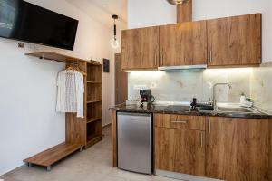a kitchen with wooden cabinets and a sink and a dishwasher at Sea U in Kalívia +31 photos