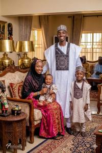 a man and a woman and two children in a living room at Aromat villa in Kano