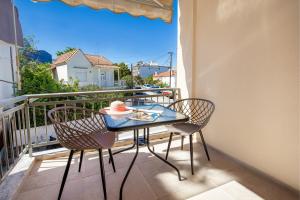 a table and chairs on a balcony with a view at Sea U in Kalívia