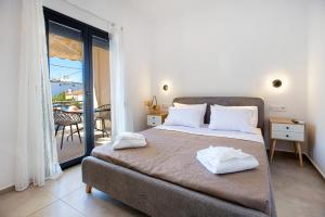 a bedroom with a bed with a view of a balcony at Sea U in Kalívia