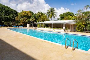 a large swimming pool in a resort with trees at Golden View Unit 204 in Saint James