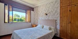 a small bedroom with a bed and a window at COSMA HOUSE in Hinojedo +65 photos