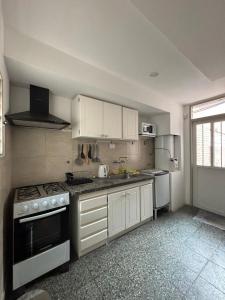 a kitchen with white cabinets and a stove top oven at Duplex Los Molles in Santa Rosa