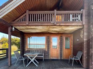 eine Holzhütte mit Tisch und Stühlen auf einer Terrasse in der Unterkunft Seaside Cabin in Aabla