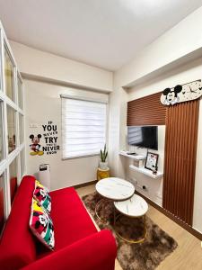 a living room with a red couch and a table at Hope residences 501 building b in Trece Martires