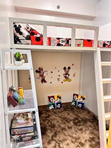 a bunk bed with mickey mouse stickers on the wall at Hope residences 501 building b in Trece Martires