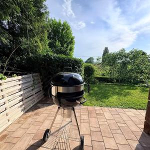 a grill sitting on a stand on a patio at Villa ZöldFüge in Balatonfůzfő