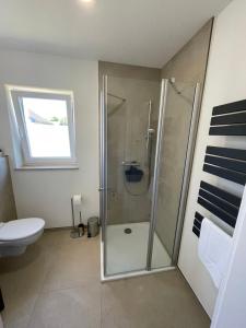 a bathroom with a shower and a toilet at Ferienwohnung Bahnblick - Stilvoll in bester Lage - als Wohnung oder Haus in Olbersdorf +15 photos