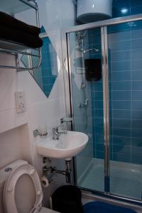 a bathroom with a toilet and a sink and a shower at Reno's Guest House in Birżebbuġa