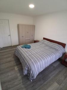 a bedroom with a large bed with a striped blanket at Refugio Austral in Punta Arenas