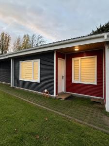 a home with a red and black house at Refugio Austral in Punta Arenas