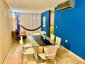 a dining room with a glass table and white chairs at Coral Suite Excellent location in Porlamar