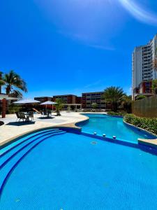a large blue swimming pool in front of a building at Coral Suite Excellent location in Porlamar