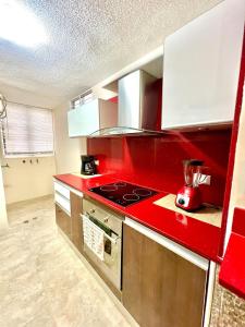 a kitchen with a red counter top with a stove at Coral Suite Excellent location in Porlamar