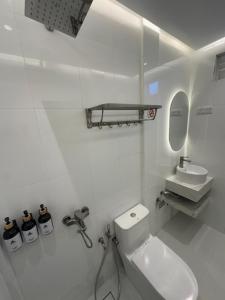 a white bathroom with a toilet and a sink at Moodhu Surf House in Himmafushi +34 photos
