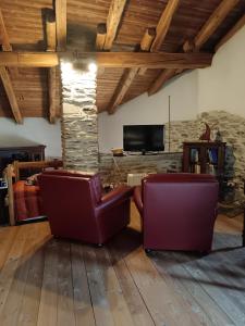 a living room with two chairs and a tv at Casa delle Rose - Marmora in Marmora