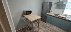 a small kitchen with a table with a microwave at Estafeta Apartament in Ponferrada
