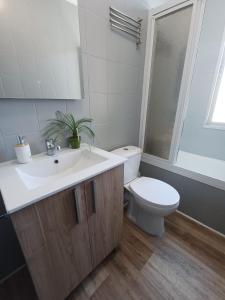 a bathroom with a white sink and a toilet at Estafeta Apartament in Ponferrada
