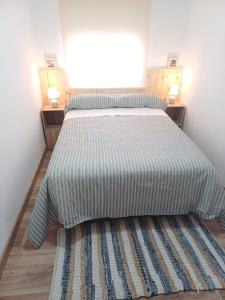 a bedroom with a bed with a striped bedspread at Estafeta Apartament in Ponferrada