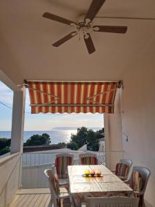 a table and chairs on a balcony with a ceiling fan at Tucepi Kamena 57 in Tučepi
