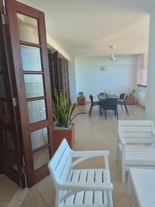 a room with white benches and a room with a table at Ocean View Apartment D5 in Mombasa
