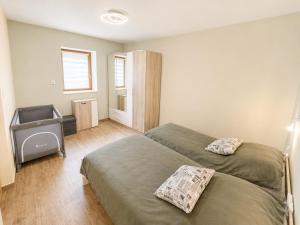 a hotel room with two beds and a television at Zója Apartmanház in Nagykanizsa