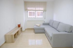 a living room with a couch and a window at Apartament Esmolet in La Pobla de Segur
