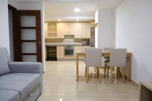a kitchen and dining room with a table and chairs at Apartament Esmolet in La Pobla de Segur