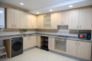a kitchen with white cabinets and a washer and dryer at Apartament Esmolet in La Pobla de Segur