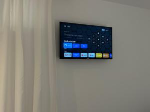 a tv on a wall next to a curtain at Minho AL in Paredes de Coura