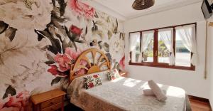 a bedroom with a flowery wallpaper on the wall at COSMA HOUSE in Hinojedo