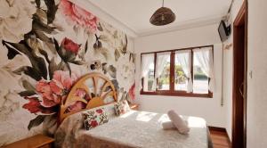 a bedroom with a flower mural on the wall at COSMA HOUSE in Hinojedo