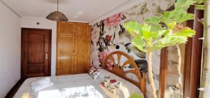 a bedroom with a bed and a floral wall at COSMA HOUSE in Hinojedo