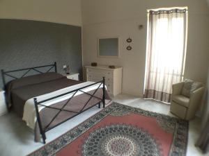 - une chambre avec un lit, une chaise et une fenêtre dans l'établissement Crawford Home, à Sant'Agnello