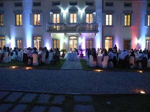 a group of people sitting at tables in front of a building at Villa Del Papa in Lucca +166 photos