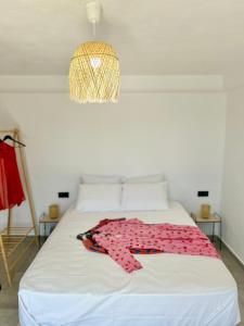 a bedroom with a bed with a pink shirt on it at Salty Rock - Kythnos Suite in Kithnos
