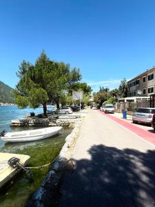 a street next to a body of water with boats at Tetka Apartments in Kotor