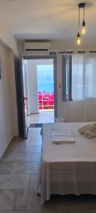a bedroom with a large white bed with a view at Thea Monastiraki in Nafpaktos