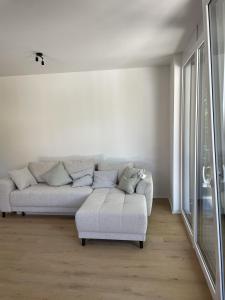 a white living room with a couch and a chair at M&S Apartments - Self Checkin in Degerfelden