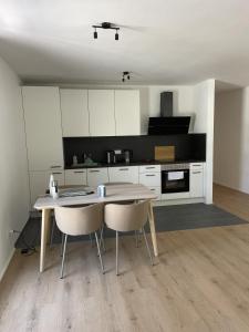 a kitchen with a table and chairs in a room at M&S Apartments - Self Checkin in Degerfelden