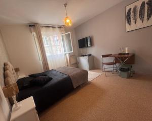 a bedroom with a bed and a table and a desk at Studio centre ville in Évreux