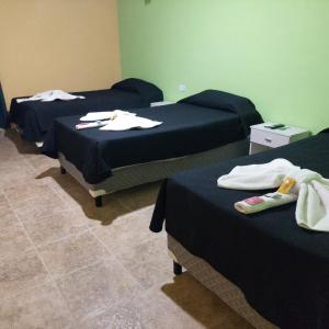 drei Betten in einem Zimmer mit Handtüchern darauf in der Unterkunft Hotel Arauco in Aimogasta