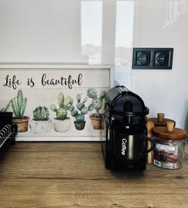 a coffee maker sitting on a floor next to a sign with cactus at Salty Rock - Kythnos Suite in Kithnos
